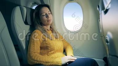 漂亮的女人睡在飞机的机舱里