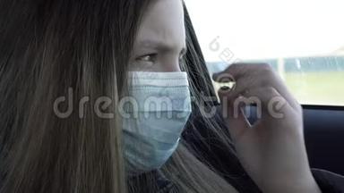 隔离概念。 戴口罩的恶心的小女孩坐在汽车后座上。 戴防护口罩的伤心女孩