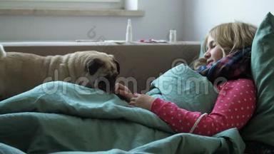 发烧的女孩和一只可爱的狗躺在家里的沙发上。 患有<strong>鼻炎</strong>及在床上咳嗽的患病儿童