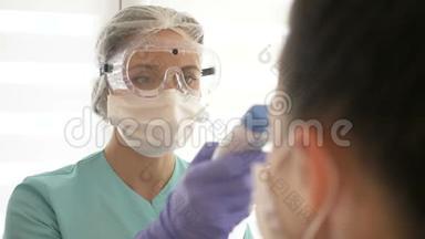 护士戴着医用面罩和眼镜，用非接触式红外<strong>温度</strong>计<strong>测量</strong>病人的<strong>温度</strong>。