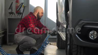 汽车修理厂的专业技工在客车上更换车轮