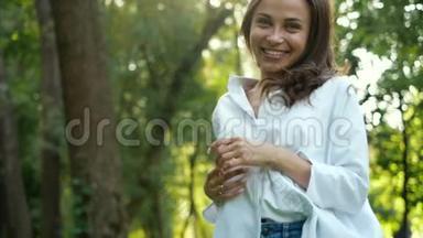 一个美丽的微笑的女人，绿眼睛，<strong>蹦蹦</strong>跳跳，摆出一张好的纪念品照片，在一个城市的秋天公园里。