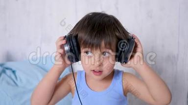 一个穿着蓝色T恤，带着耳机<strong>听音乐的男孩</strong>