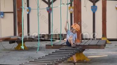 婴儿正在街上的一个绳镇玩耍。 一个男孩走在孩子们`设备上，摔倒了。 一个孩子在蹒跚的木头上