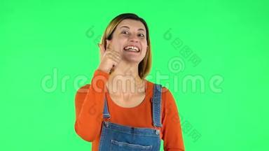 年轻开朗的女人竖起大拇指，手势喜欢。 绿色屏幕