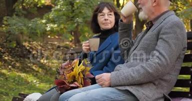 一对老夫妻的茶会，带着一束秋叶。 慢动作家庭户外活动