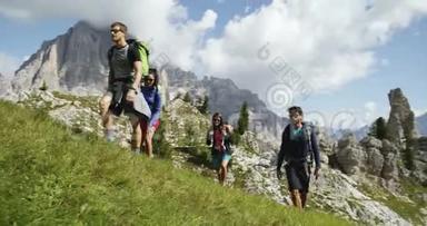 四个朋友沿着野生徒步小径散步。 一群朋友在山区大自然中进行夏季探险之旅