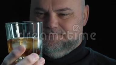 <strong>大胡子男人</strong>喝威士忌加冰块。 孤立于黑色背景特写肖像。 酗酒和酗酒
