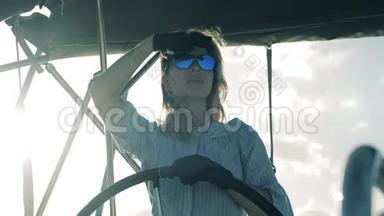 一个女孩驾驶游艇，掌舵。 海上旅行，一位女船长的暑假。