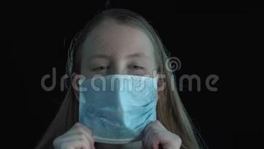 病女孩戴着医用口罩。黑色背景戴着医用面具的生病女孩的肖像