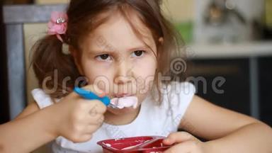 婴儿食品。 可爱的女孩在厨房里吃奶酪。 儿童早餐吃酸奶的肖像