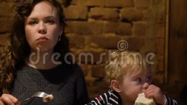 年轻女子带着小男孩在餐馆酒吧吃鲜肉