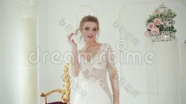 身穿白色婚纱的金发新娘摆<strong>姿势拍照</strong>，用手指抚摸对方