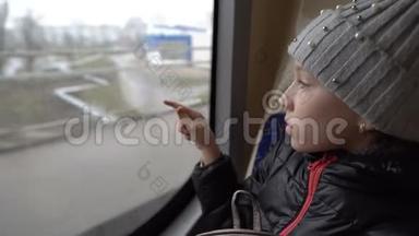 一个小女孩在一辆旅行巴士上雾蒙蒙的窗户上画了一颗心。 从巴士里面看。 背景模糊。 特写