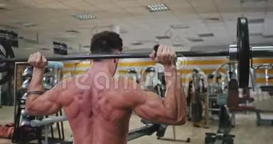 从一个健美男子的背部拍摄视频，他在现代健身房锻炼背部以获得更多的肌肉