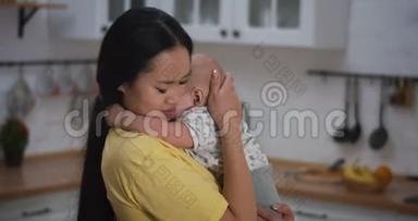 妈妈抱着哭泣的婴儿抱在怀里