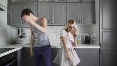 有趣的年轻人在家里的厨房里<strong>一起</strong>笑，<strong>一起</strong>傻，<strong>一起</strong>跳舞