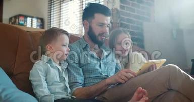 年轻快乐的白种人单身爸爸用平板电脑和可爱的小儿子和女儿一起在家慢动作。