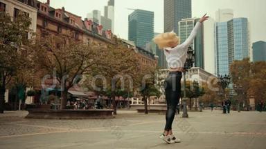 年轻的女舞者芭蕾舞女演员金发女郎在现代都市的大街上跳舞