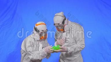 呼吸器医生展示病毒模型。 慢动作。 女佩戴防护医用气雾剂喷漆口罩.. 绿色球球