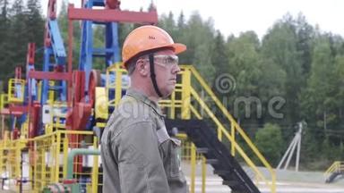 石油工人监督原油生产现场的慢镜头。 工业油泵千斤顶工作和抽油