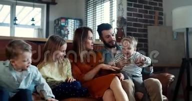 幸福的家庭和传统的价值观理念，年轻的高加索父母在沙发上和三个孩子一起慢动作。