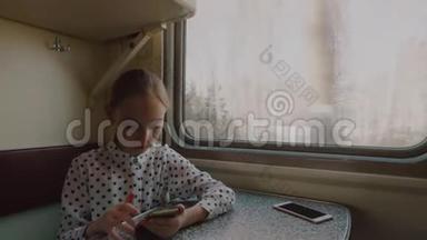 旅游女孩青少年浏览智能手机在乘坐火车前窗口。 年轻的旅游女孩在火车上用手机