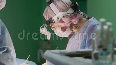 现代医学，一组外科医生做手术。 现代医疗设备使外科医生能够进行精细操作