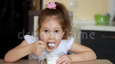 小女孩吃酸奶和奶酪加麦片。 儿童早餐吃乳制品。