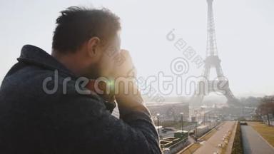 后景快乐自由摄影师男子拍摄巴黎埃菲尔铁塔的照片与复古电影相机慢动作。