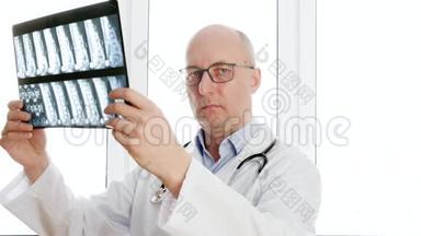 男外科医生在诊所办公室的前窗里看背骨x光。 男医生拿着x光<strong>脊椎</strong>骨