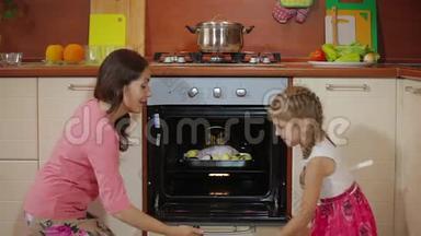 年轻的妈妈在厨房教可爱的女儿做饭，幸福的家庭小女孩帮妈妈做饭美味的食物