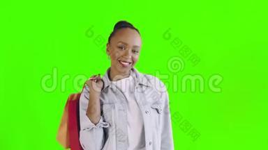 画室绿色背景上带<strong>购物</strong>袋的非裔<strong>美国</strong>妇女肖像。 快乐的女人在<strong>购物</strong>