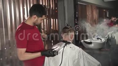 理发师用电动剃须刀把头发剃在后脑勺上。 穿红色t恤的理发师在理发店理发