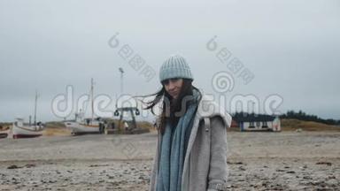 美丽的快乐女游客在冬季大衣在<strong>风</strong>低<strong>潮</strong>冷波罗的海海滩与船慢运动的肖像