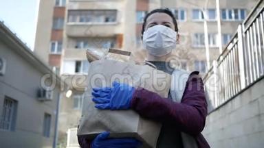 食品<strong>配送</strong>年轻妇女戴着防护面罩和手套，携带来自商店的产品。 流行病
