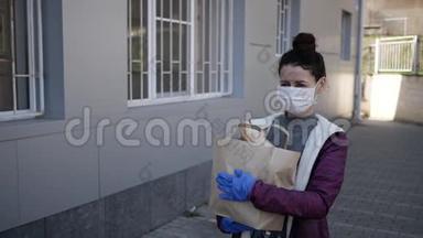 食品<strong>配送</strong>年轻妇女戴着防护面罩和手套，携带来自商店的产品。 流行病