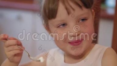 小女孩在厨房里在家聊天，吃<strong>冰淇淋</strong>。 可爱的小女孩笑着吃<strong>冰淇淋</strong>