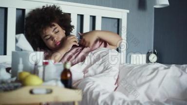 生病的非裔美国女孩患流感躺在家里的床上。 我年轻的黑人女人，在寒冷的温度下
