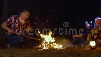 在森林远足营地<strong>生火</strong>的游客。在篝火旁放松的旅行家庭。少女玩耍