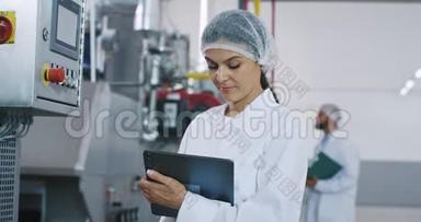 一位女工程师带着新一代平板电脑的画像在检查工业机器时做了一些笔记