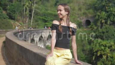 女孩坐在<strong>历史</strong>桥上，<strong>微</strong>笑着面对野生森林