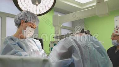 手术期间的手术团队.. 外科医生是一个友好的团队，蓝色现代手术室的专业人士