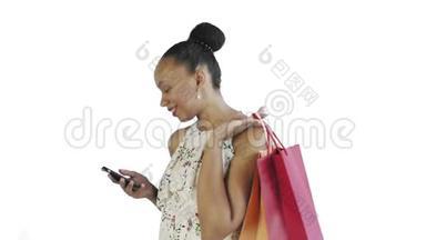 在录音室里，一位拿着购物袋的非裔美国妇女正在用白色背景的智能手机交谈。白色
