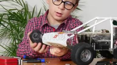 小男孩在家修理一辆无线电控制的<strong>汽车模型</strong>