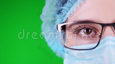 绿色背景。特写镜头，眼睛，部分女医生脸戴眼镜，戴蓝色医用面罩和医用帽。