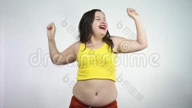身体健康。一个大肚皮的胖女孩，兴奋地跳着舞，微笑着