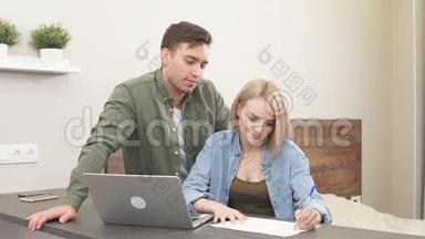 夫妻俩在家里用笔记本电脑算账