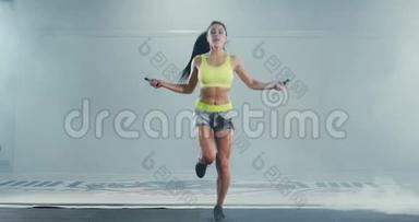 运动肌肉的女人跳绳。