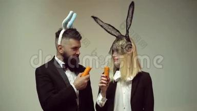有趣的一对<strong>兔子</strong>吃胡萝卜。 <strong>兔子</strong>耳朵概念与<strong>兔子</strong>夫妇。 活泼的复活节夫妇。